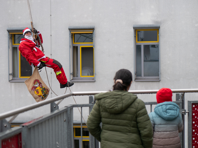 Weihnachtliche Freude vom Dach: Nikoläuse der Würzburger Feuerwehr überraschen Patienten der Missio Kinderklinik